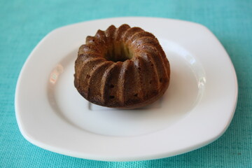 A small shaped cupcake on a white plate.