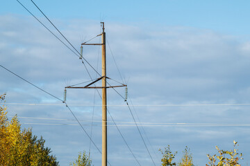 Power lines on the background of the blue sky close-up. Electric hub on a pole. High voltage wires