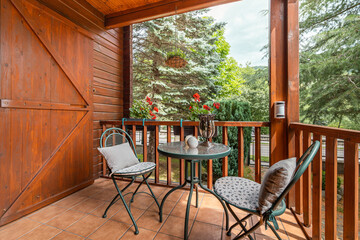 Porch terrace in wooden rustic house with table and chairs