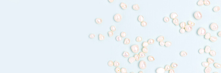 Banner with white pearl beads scattered on a blue background. Needlecraft concept.