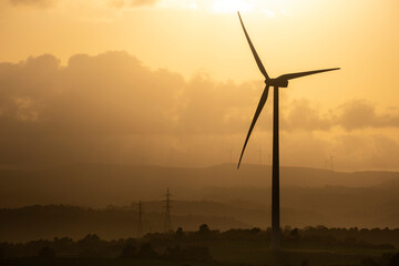 Wind turbines at sunset with the sky in the background