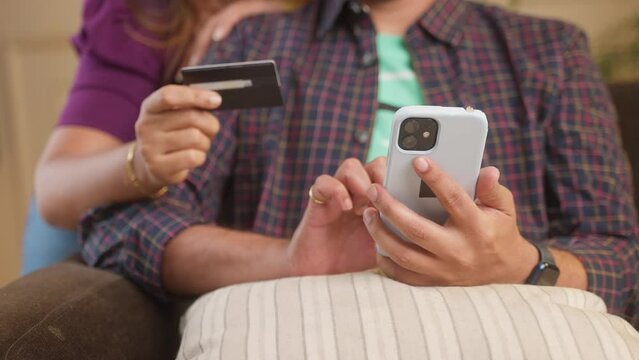close up shot of couple hands making online purchase on smartphone by using credit card at home - conept of bill payment, ecommerce shooping and secure transaction.