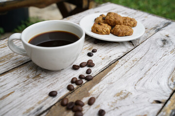 Black coffee cup with cookies on wooden floor, black coffee in the morning to drink with cookies.
