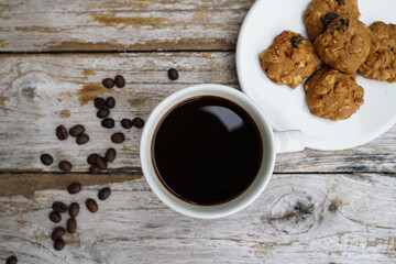 Black coffee cup with cookies on wooden floor, black coffee in the morning to drink with cookies.