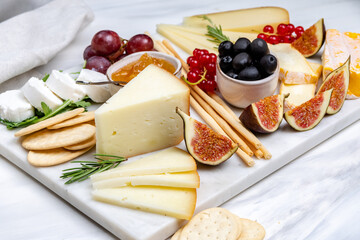 French Cheese platter with camembert, brie, Gorgonzola, parmesan, honey, figs and herbs. White...