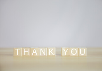 Wooden block showing a message, the word thank you.