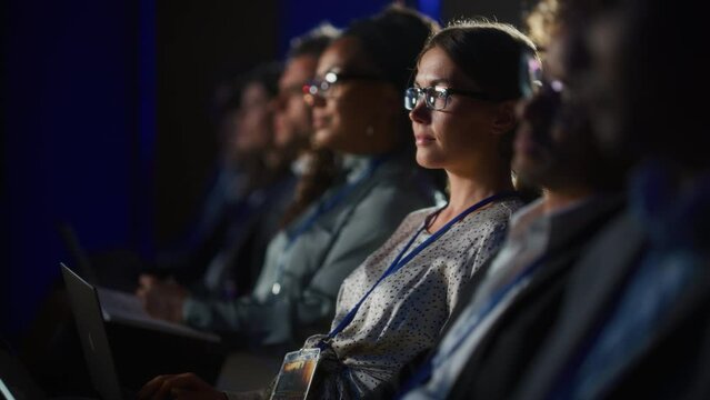 Young Psychologist Attending an International Cognitive Behavioral Therapy Seminar. Specialist Using Laptop Computer. Psychotherapy Professional Sitting in a Crowded Room on a Training Program.