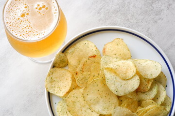 のり塩味のポテトチップスとよく冷えたビールのグラス