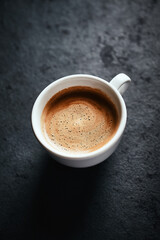 Cup of coffee on dark stone background. Close up. Copy space.
