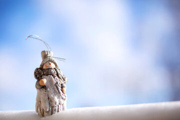 Winter Christmas, New Year concept card with Snowman toy decoration in the snow on blue sky background