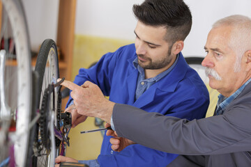 Mechanic checking chain tautness on bicycle