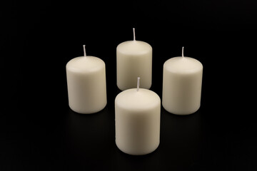 White candles on dark background. Close-up, copy space.