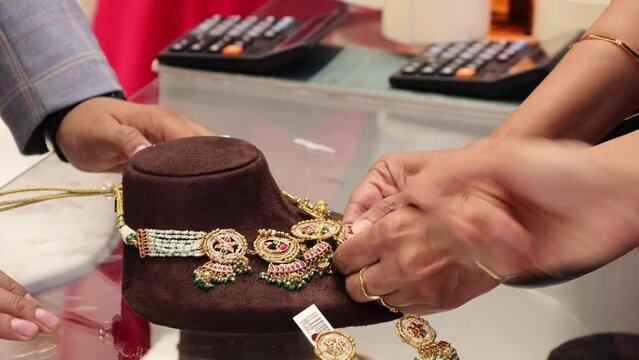 Bangalore, India 4th May 2022: Indian customer in a jewellery exhibition buying gold on the occasion of Dhanteras and Vijayalaxmi. Traditional ornaments with marvelous stones and intricate designs.