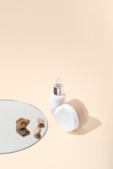  Natural cosmetics (serum, cream) with white truffle   extract on a beige neutral background. White truffle extract full of antioxidants and vitamins, anti-aging, conceptual still life with a mirror