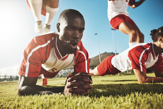 Sports, soccer and football team doing push up before game, match or tournament for health, fitness and exercise for warm up. Black men, workout and training group on outdoor field for sport practice