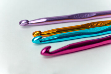 Multicolored hooks of different diameters for knitting on a white background. On a horizontal background. Suitable for hobby, handmade, craft and home leisure sites.