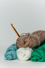 Multicolored threads with an orange hook on a white background. Vertical format. For handmade,...