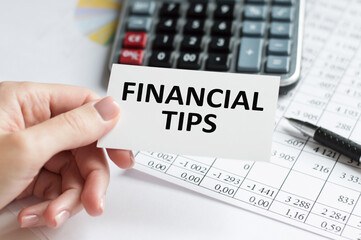 FINANCIAL TIPS word inscription on white card paper sheet in hands of a businessman. recap concept. red and white paper