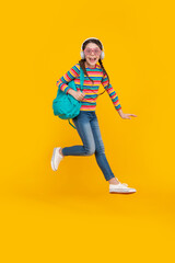 Fototapeta na wymiar Happy energetic teenage girl jumping after school yellow background, school. Back to school