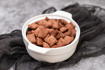 chocolate cereals in small white bowl on ceramic