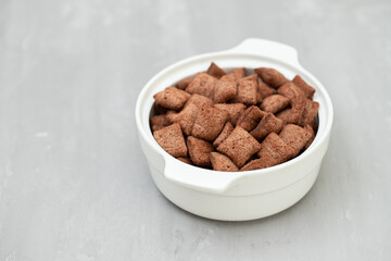 chocolate cereals in small white bowl on ceramic