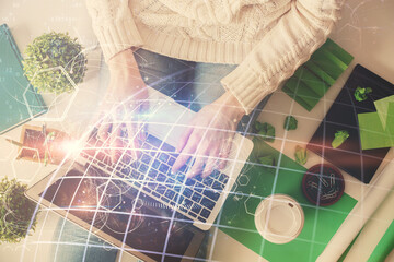 Double exposure of woman hands working on computer and world map hologram drawing. Top View. International business concept.