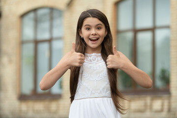 Fototapeta premium pretty teen girl. adorable girl fashion model. portrait of teenager girl outdoor. thumb up