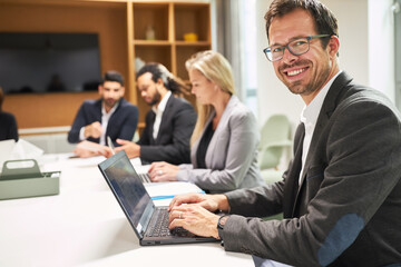 Lächelnder Geschäftsmann arbeitet am Laptop Computer
