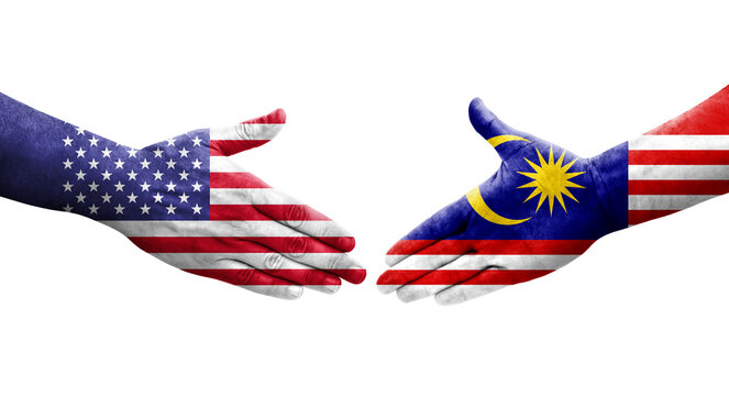 Handshake between Malaysia and USA flags painted on hands, isolated transparent image.