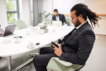 Junger Business Mann sitzt nachdenklich am Konferenztisch