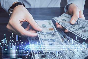 Double exposure of technology drawing hologram and us dollars bills and man hands. Data concept