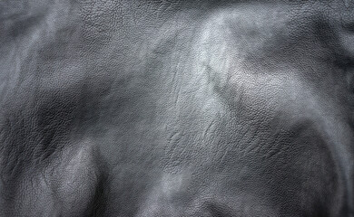 Black leather background for text. Photo of the texture of genuine leather for making clothes. The background is black.
