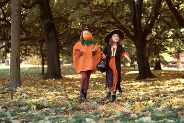 Two caucasian girls walking in the woods in Halloween outfits