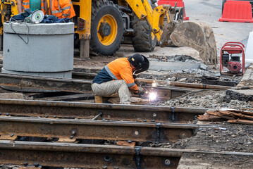 A worker welder conducts repair work on the railway tracks. Cutting metal by welding.