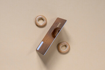 percent sign made from a credit card and bagels on a light background. copy space.