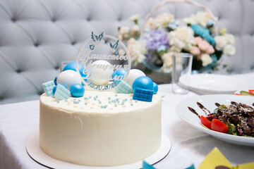 white cake with blue decor, the inscription on the cake 