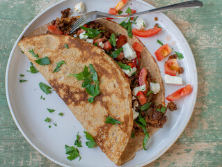 Savory pancake with ground beef, onion, tomatoes and feta cheese