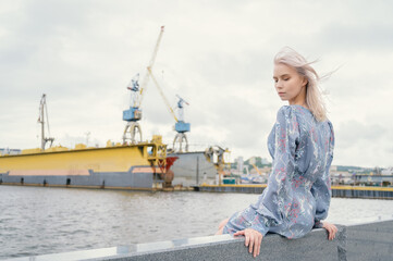 Woman in blue dress enjoys sea shore.