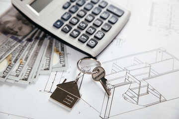 A blueprint of an architect with a calculator, money and home key. Cost of building of a new house