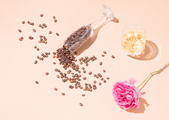 Spilled coffee beans on the background. Rose and a glass of whiskey. Creative composition.