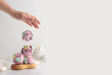Traditional Russian homemade merengue marshmallow or zephyr flowers with a human hand