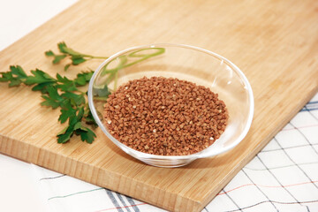 small grains of natural brown buckwheat in a transparent glass plate