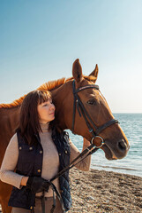 Obraz premium Selective focus. Girl and horse. Horse riding by the sea.