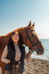 Obraz premium Selective focus. Girl and horse. Horse riding by the sea.