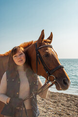 Obraz premium Selective focus. Girl and horse. Horse riding by the sea.