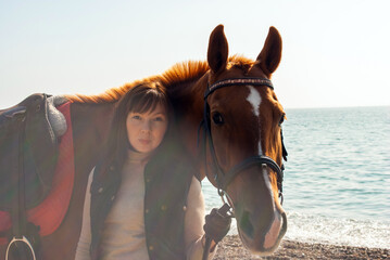 Obraz premium Selective focus. Girl and horse. Horse riding by the sea.