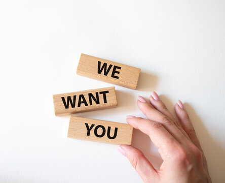We want you symbol. Concept words We want you on wooden blocks. Beautiful white background. Businessman hand. Business and We want you concept. Copy space.