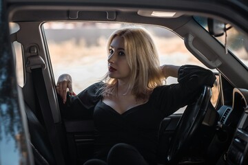 Naklejka na ściany i meble Gorgeous blonde woman in a car, luxury style, concept lady and automobile vibe