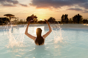 ragazza in piscina al tramonto