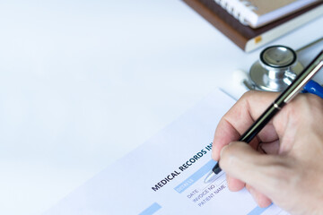Male doctor writing information medical records invoice.